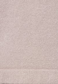 Ljusrosa stickad tyg med ribbad textur och rak fåll. Materialet verkar mjukt och elastiskt, lämpligt för avslappnad användning.