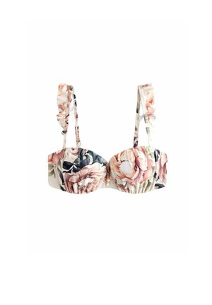 Blommig bralette med volangremmar, prydd med stora rosa och marinblå blommor mot en krämfärgad bakgrund, tillverkad av mjukt tyg med en rynkad design.