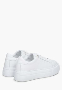 Witte leren sneakers met een gestructureerd patroon, platte rubberen zolen, metalen oogjes en een afgeronde neus. Heeft een gladde afwerking en subtiele accenten.