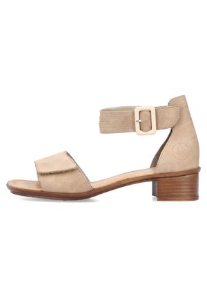 Beżowe sandały z odkrytymi palcami, z regulowanym paskiem na kostkę, niskim drewnianym obcasem i wyściełaną wkładką.