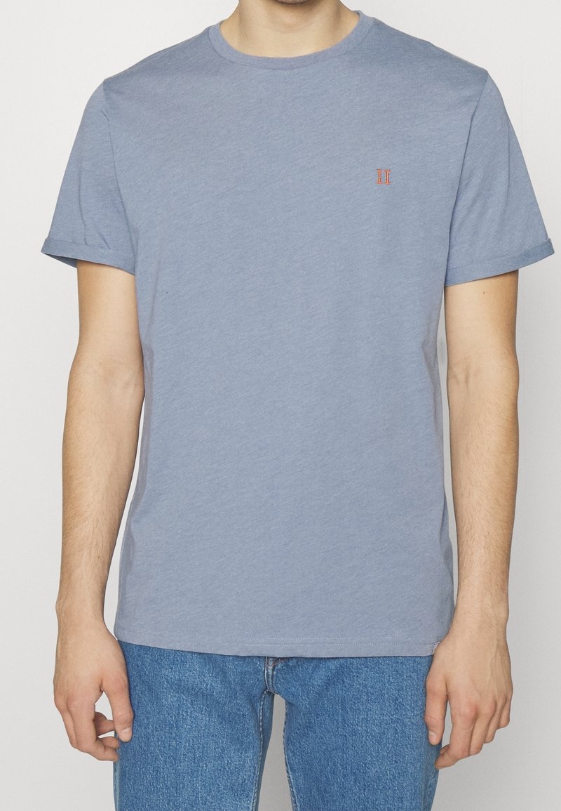 Light blue cotton t-shirt with short sleeves, a crew neck, and a small red embroidered detail on the chest. Casual fit.