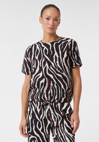 Kurzarmshirt aus leichtem Stoff mit einem Zebra-Muster in Schwarz, Creme und Rot; legere Passform mit Rundhalsausschnitt und elastischem Saum.