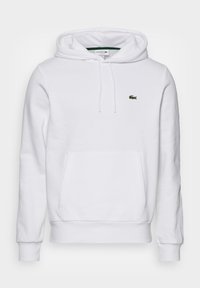 Sweat-shirt à capuche blanc avec poche kangourou à l'avant et petit logo crocodile vert sur la poitrine gauche.