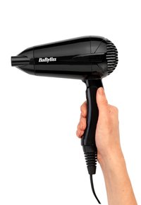 Mano che tiene un asciugacapelli BaByliss nero con cavo, mostrato su sfondo bianco.