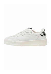 Baskets en cuir blanc avec bout rond, devant lacé et semelle en caoutchouc texturé. Présente une accentuation noire et blanche rayée sur le talon.
