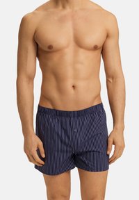 Shorts de boxeur rayés bleu marine en tissu léger, avec une taille élastique et une fermeture à un bouton à l'avant.