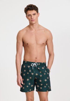 Bañadores de hombre, verde oscuro con un patrón de estrellas de mar en durazno, cintura elástica con cordón, bolsillos laterales, tejido suave.