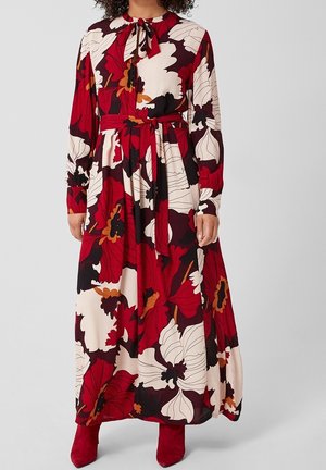 Maxi-jurk met lange mouwen met rode, witte, zwarte en oranje oversized bloemenprint, gebonden taille en bijpassende rode enkellaarzen.