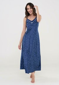 Vestido maxi sin mangas de color azul marino con patrones de estrellas blancas, escote en V con ribete en contraste y aberturas laterales para mayor comodidad al moverse.