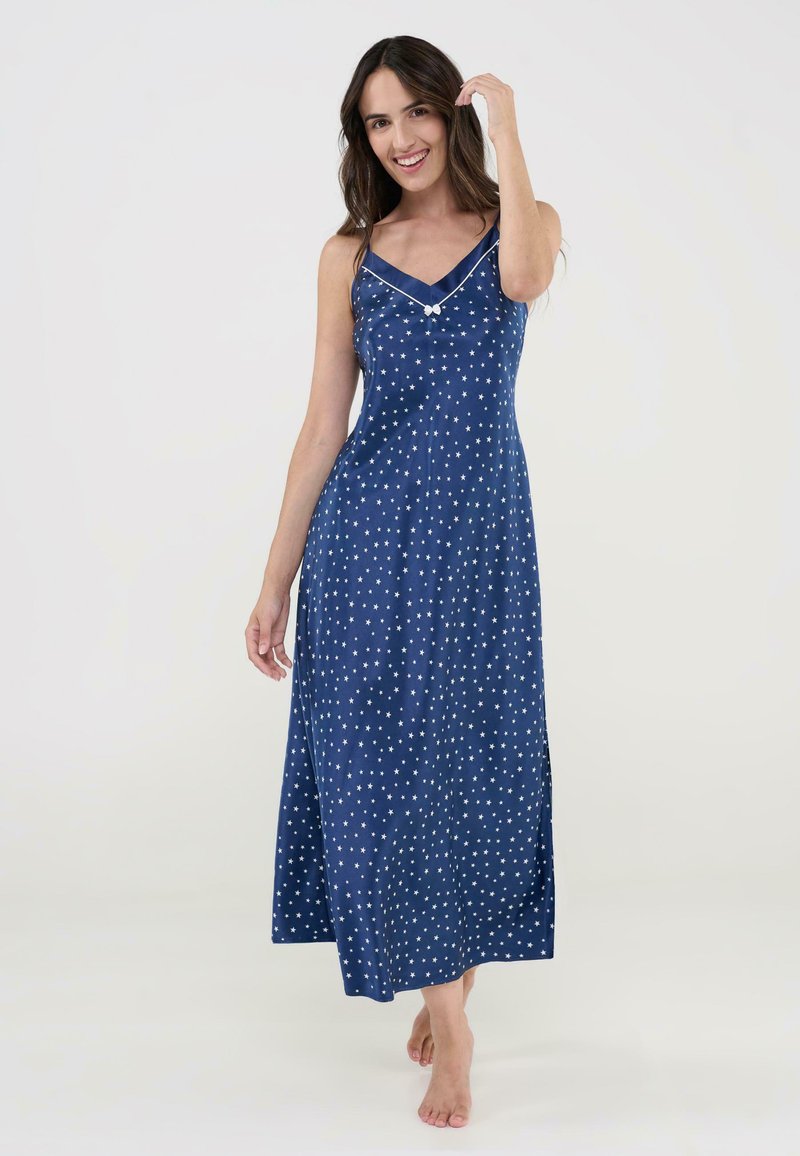 Vestido maxi sin mangas de color azul marino con patrones de estrellas blancas, escote en V con ribete en contraste y aberturas laterales para mayor comodidad al moverse.