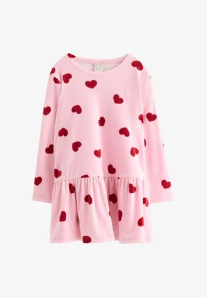 T-shirt de mangas compridas rosa com uma bainha de babados e padrões de corações vermelhos espalhados; feito de um tecido suave para conforto e facilidade de movimento.