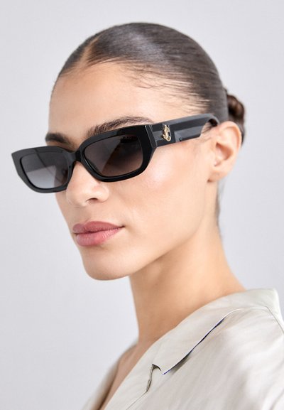 Black rectangular sunglasses with tinted lenses, featuring chunky frames and gold hardware detail on the temples. Smooth, glossy texture.