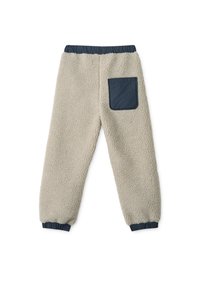 Beige színű polárnadrág, rugalmas derékkal és sötétkék zsebbel. Bordás mandzsettákkal és texturált, puha anyaggal rendelkezik.