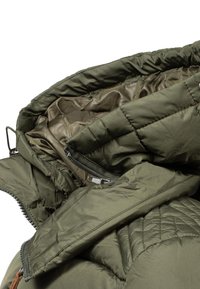 Giacca a vento verde oliva con texture trapuntata, tasche con zip e cappuccio; la fodera interna presenta una finitura liscia e lucida.