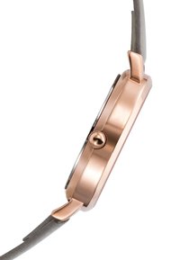 Reloj de oro rosa con un perfil delgado, caja de metal, correa texturizada gris y una esfera redonda. Cuenta con una corona en el lateral para ajustes.