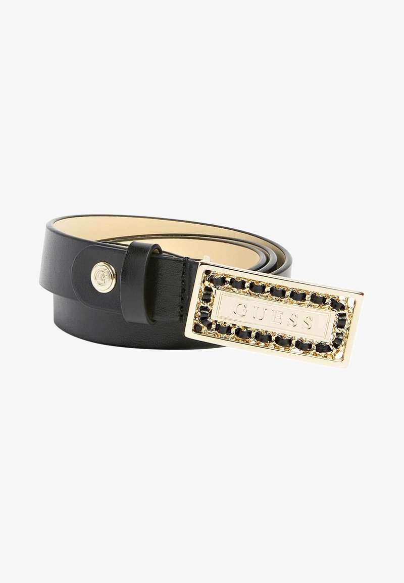 Ceinture en cuir noir avec boucle rectangulaire dorée ornée de pierres noires et "GUESS" gravé au centre, enroulée sur un fond blanc.