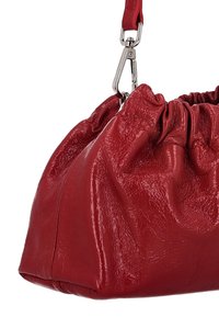 Sac à main en cuir rouge avec un design froncé et une surface texturée. Doté d'une fermeture à pince en métal argenté et d'une courte sangle.