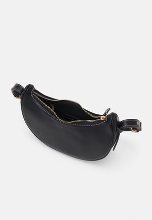 Sac en cuir noir en forme de croissant avec une fermeture éclair dorée partiellement ouverte, montrant une poche intérieure ; bandoulière réglable avec boucle dorée.