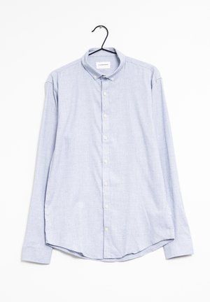 Camicia a maniche lunghe azzurro chiaro con bottoni e colletto, appesa a una gruccia nera su sfondo bianco.