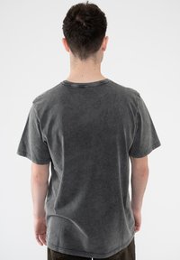 Gray cotton T-shirt featuring a relaxed fit, short sleeves, and a ribbed crew neckline. Soft texture with a faded finish.