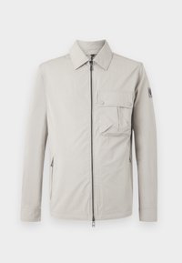 Giacca grigia chiara con zip frontale, colletto a punta, tasca sul petto con patta e cerniere laterali, realizzata in tessuto liscio con finitura opaca.