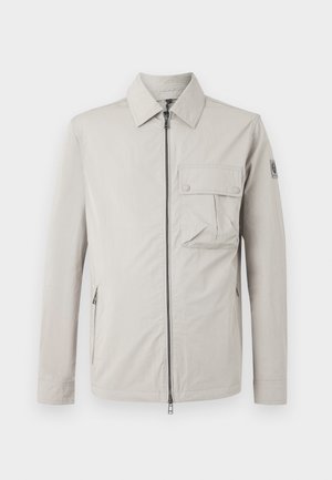Light gray jacket featuring a zip front, pointed collar, chest pocket with flap, and side zippers, made of smooth fabric with a matte finish.