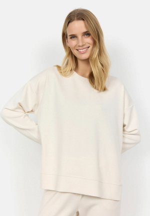 Felpa beige chiaro realizzata in tessuto morbido, caratterizzata da una vestibilità rilassata, spalle cadute e scollo arrotondato, che arriva fino a metà fianchi.