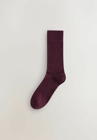 Șosetă burgundy cu o textură netedă, cu manșetă ribbată și lungime clasică de tip crew. Design fără cusături pentru confort, potrivită pentru purtarea casual.