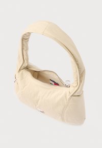 Beežist nailonist käekott kaarjalt painduva käepidemega, lukuga sulguv ja sileda tekstuuriga. Alumise osa lähedal väike logoga dekoratsioon.