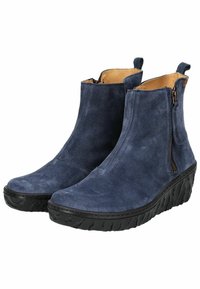 Botas de tobillo de ante azul marino con una suela de cuña negra texturizada, cremallera lateral y tirador en la parte trasera. El interior cuenta con un forro liso en tono marrón claro.