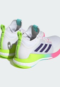 Weiße Sportschuhe mit einem oberen Teil aus Mesh, grünen Akzenten, lila Streifen und einer rosa Farbverlaufsohle. Mit Zuglaschen für ein einfaches Anziehen.