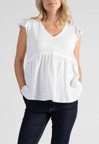 Weißes Blusenshirt mit V-Ausschnitt und kurzen, voluminösen �Ärmeln. Aus strukturiertem Stoff und mit gerafftem Hüftbereich, was eine lockere Passform bietet.
