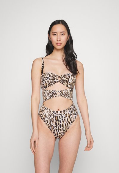 Bikini con stampa animale e design con tagli, caratterizzato da un frontale attorcigliato e dettagli in oro. Realizzato in tessuto morbido e elasticizzato.