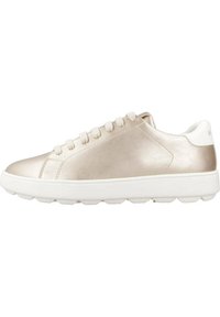 Zapatilla metálica de color champán con una textura suave, suela blanca, seis ojetes y un diseño minimalista.