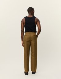 Fekete ujjatlan felső és khaki nadrág, testhezálló szabással, egyenes lábakkal és sima textúrával. A hátsó nézet a derékpántot és a zsebeket mutatja.