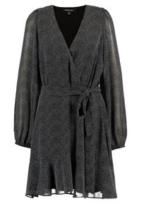 Svart omklädningsklänning med vita prickar, lång puffärm, midjeband och utsvängd nederdel, tillverkad av lätt och flödande tyg.