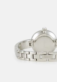 Silver-tone metal watch with a polished bracelet, round case, and engraved "Swarovski" logo on the band. Smooth texture and sleek design.