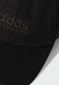 Cappello in cotone nero con logo Adidas ricamato in rilievo di colore scuro. Il design include una visiera curva e un tessuto testurizzato.
