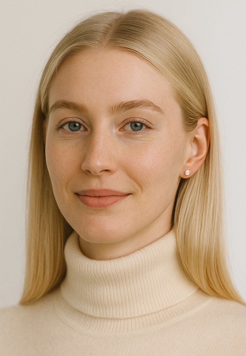 Pull à col roulé crème avec texture côtelée, cheveux blonds lisses et petites boucles d'oreilles rondes. Fond neutre qui met en valeur les traits du visage.