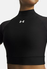 Μαύρο εφαρμοστό κοντομάνικο τοπ με ψηλό λαιμό, κατασκευασμένο από ελαφρύ, ελαστικό ύφασμα. Διαθέτει λευκό λογότυπο Under Armour στο μπροστινό μέρος.