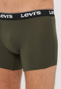 Boxer briefs verde oliva realizzati in cotone, con un elastico in vita nero che presenta il marchio "Levi's" in bianco e un design senza cuciture per il massimo comfort.