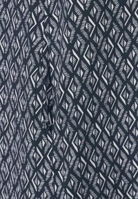 Marine-Stoff mit einem weißen geometrischen Diamantmuster. Die Textur wirkt glatt und hat scharfe Winkel sowie unterschiedliche Linienbreiten im Design.