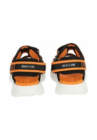 Černé a oranžové sandály s síťovaným svrškem, nastavitelnými popruhy a detailem loga. Bílá podrážka, texturovaná stélka a zpevněná pata.