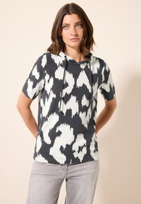Sudadera de manga corta en gris con un patr�ón abstracto en blanco y negro. Presenta una capucha con cordón y un corte relajado. Textura de tela suave.