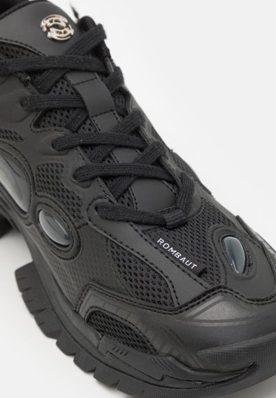 Black sneaker featuring mesh and rubber materials, round eyelets, thick sole, and "ROMBAUT" branding on the side.