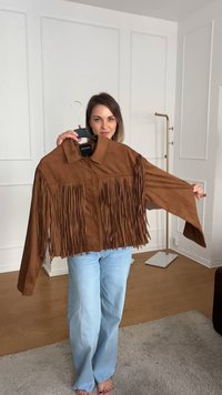 Giacca in suede marrone con dettagli in frange lungo il petto e le maniche, dotata di un collo a collare e due tasche frontali.
