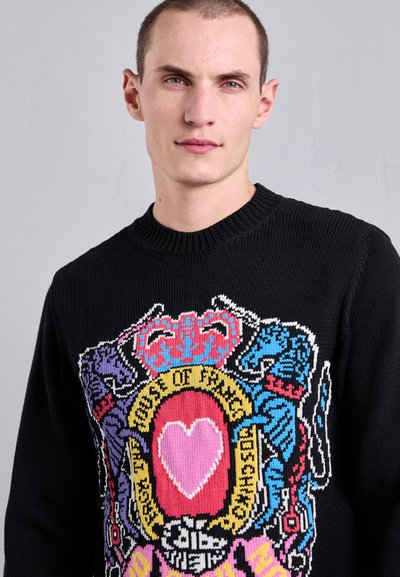 Pull en maille noir avec un design graphique coloré représentant des animaux et un cœur au centre. Encolure ronde côtelée et tissu texturé.