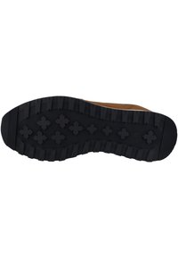 Semelle en caoutchouc noir avec un motif de semelle texturé pour une traction, avec des formes croisées surélevées et des bords robustes pour une durabilité accrue.