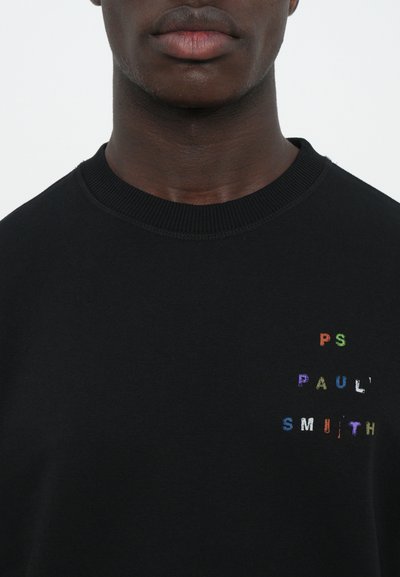 Čierna mikina so zúženým výstrihom, na prednej strane s farebným vyšívaným nápisom "PS Paul Smith". Hladká textúra, ležérny dizajn.