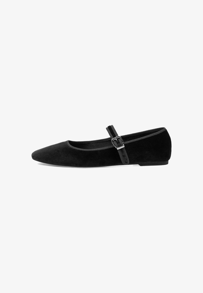 Bailarina negra hecha de suave ante, con puntera afilada y una delgada correa en el tobillo con una pequeña hebilla. Tacón plano y diseño minimalista.
